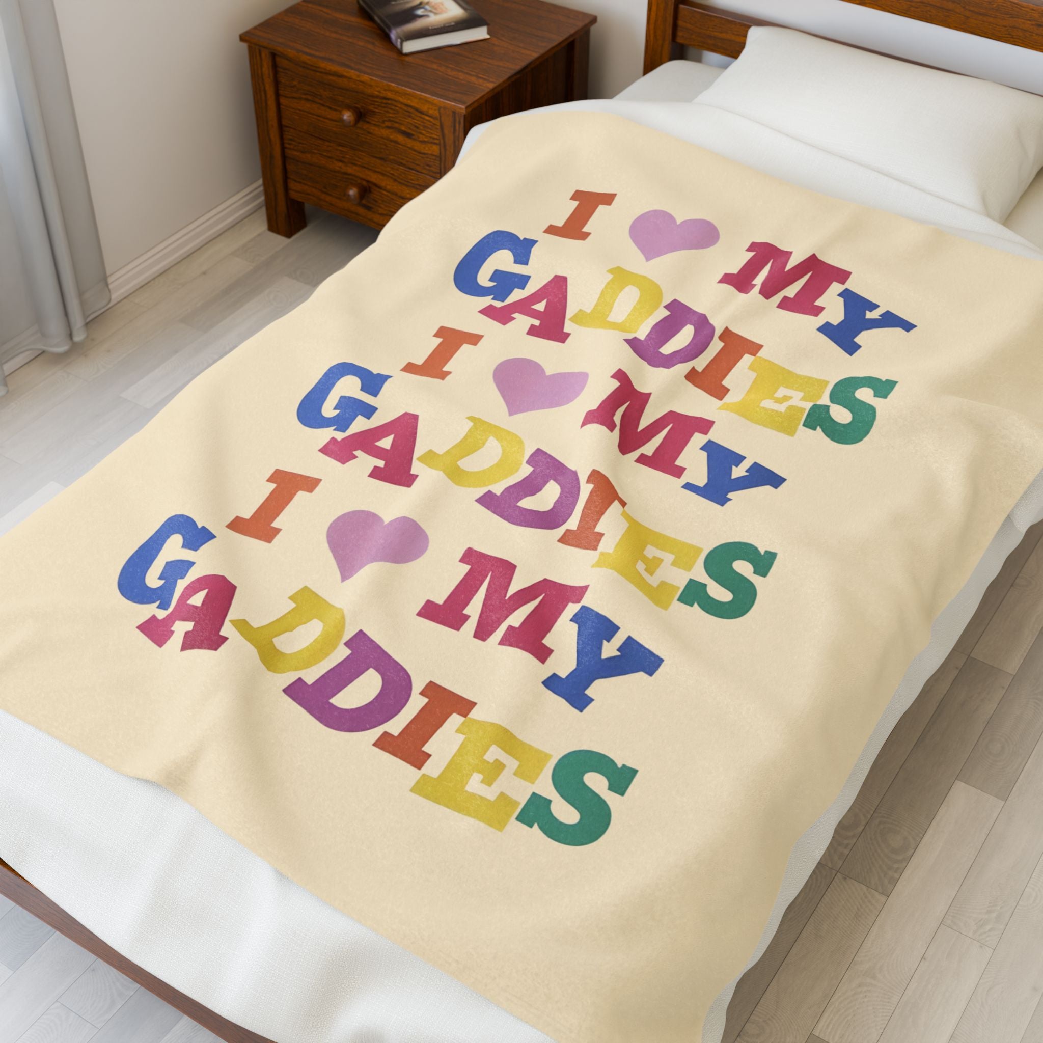 Colorful throw blanket on bed featuring bold rainbow text that says “I Love My Gaddies” – perfect LGBTQ+ gift for chosen family and pride celebrations.

