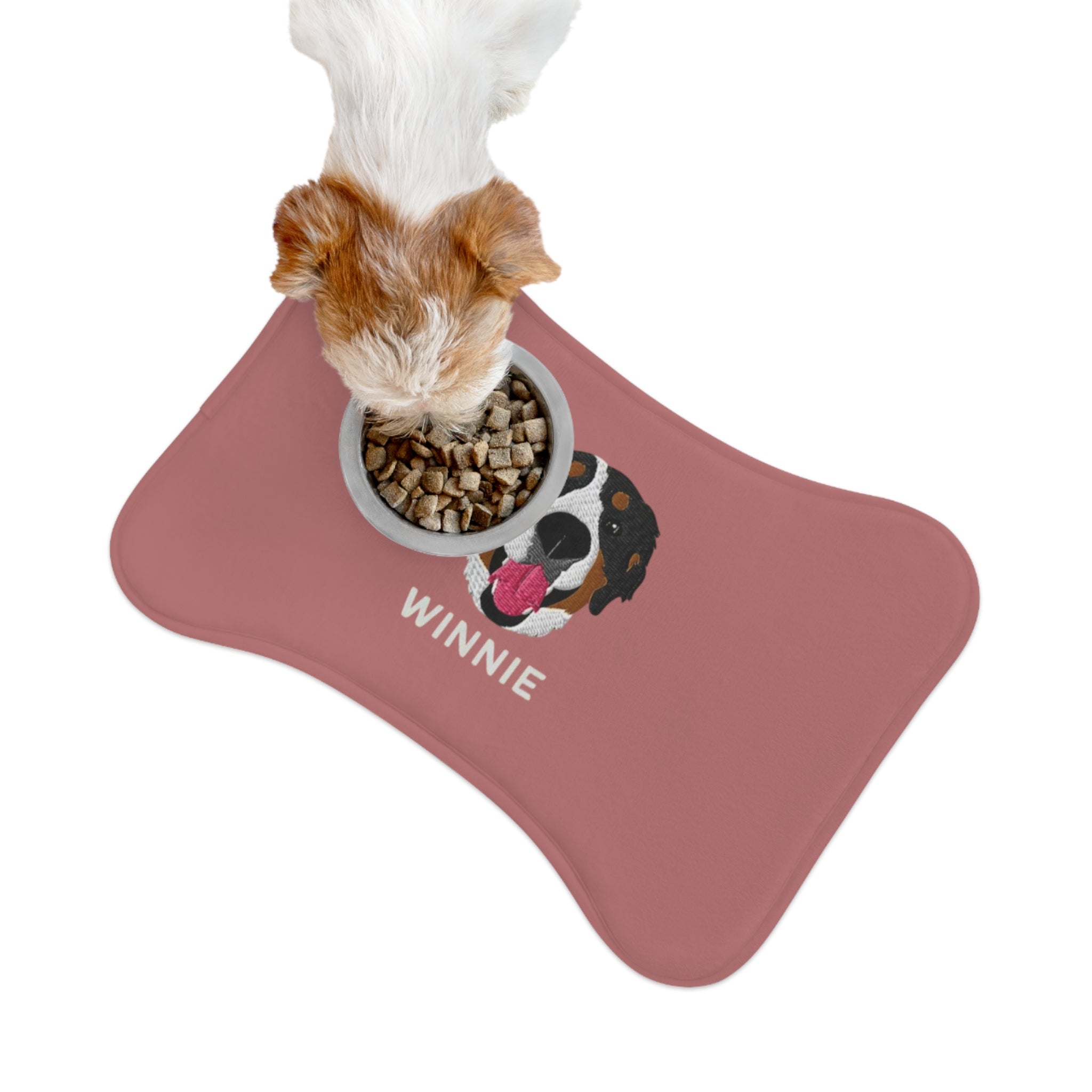 Blue bone-shaped custom feeding mat featuring an embroidered-style portrait of a Bernese Mountain Dog with the name “Winnie” printed underneath.


