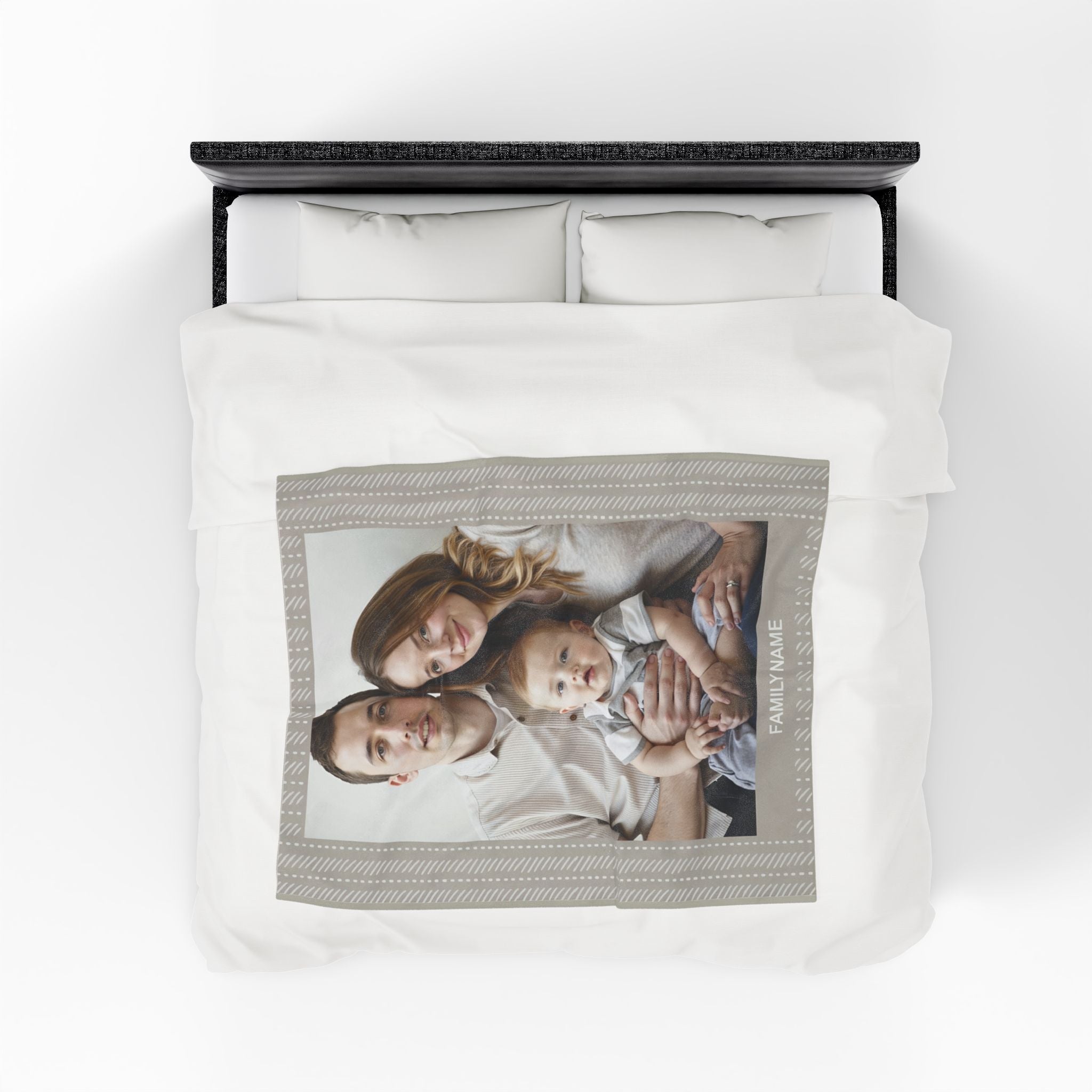 Custom photo blanket with a printed family picture and personalized name, displayed on a bed

