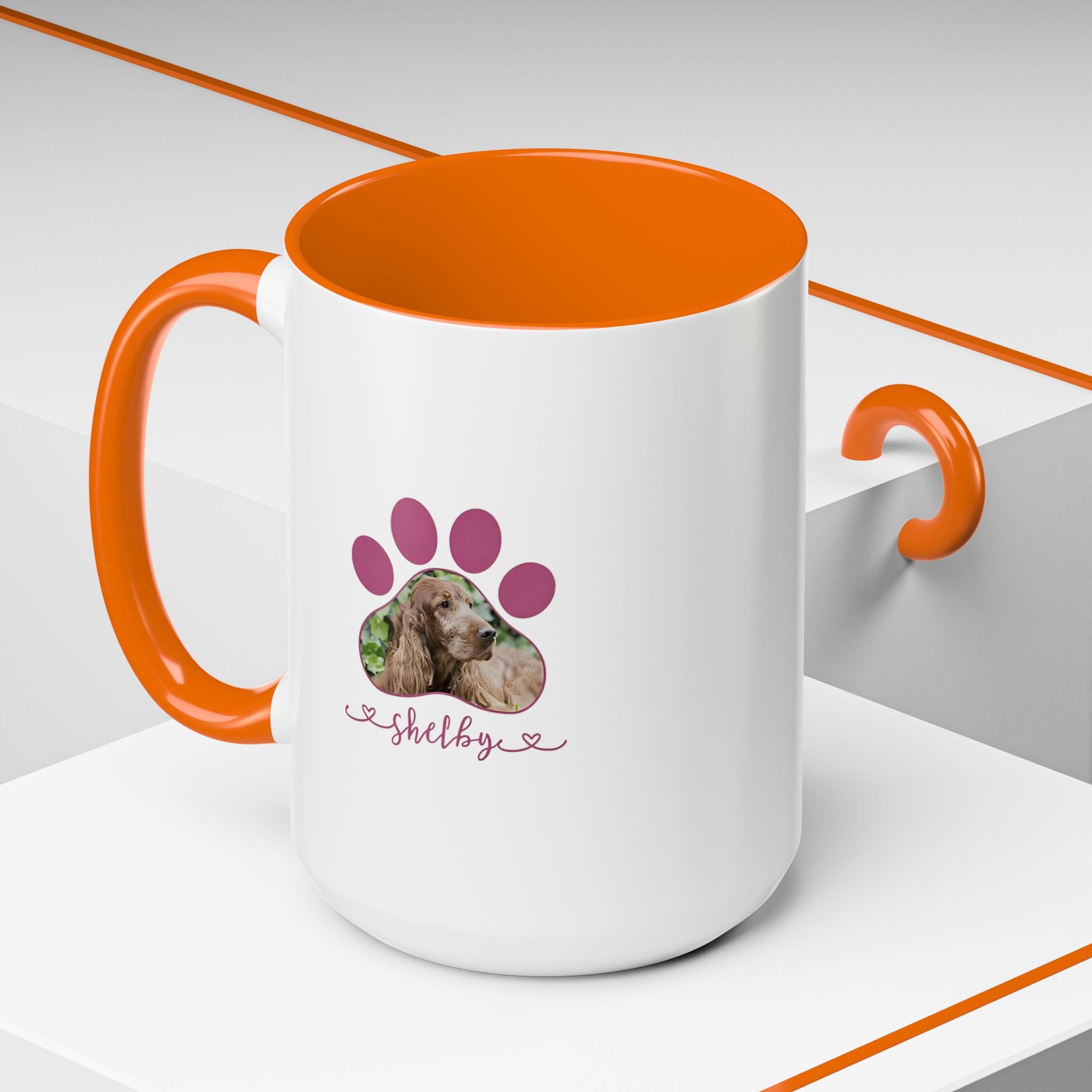 Custom pet photo mug with a paw print design and personalized dog name on white ceramic with orange handle.

