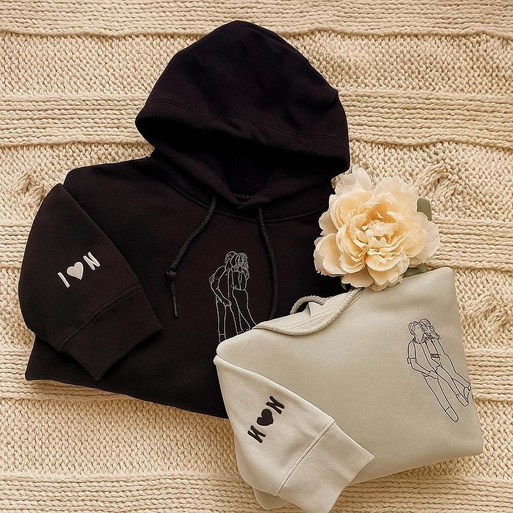 Custom embroidered couple hoodies with minimalist line art portrait design and personalized sleeve initials